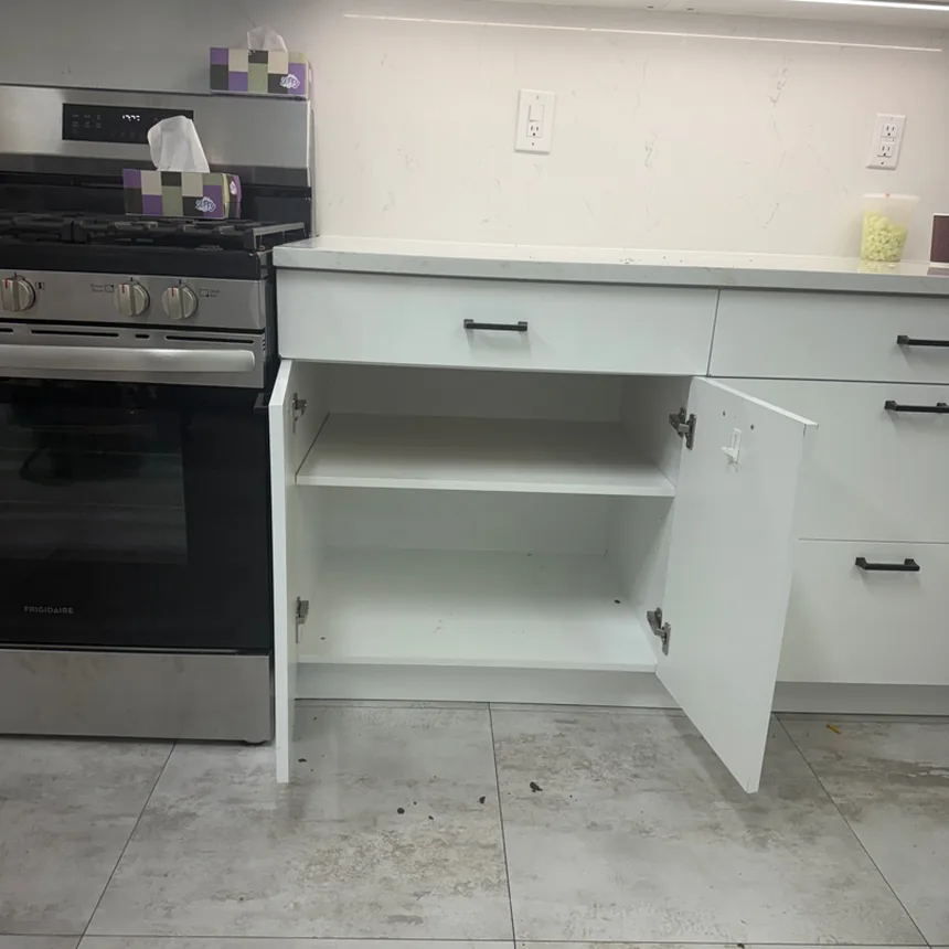 Empty white base cabinet with one fixed shelf, doors open